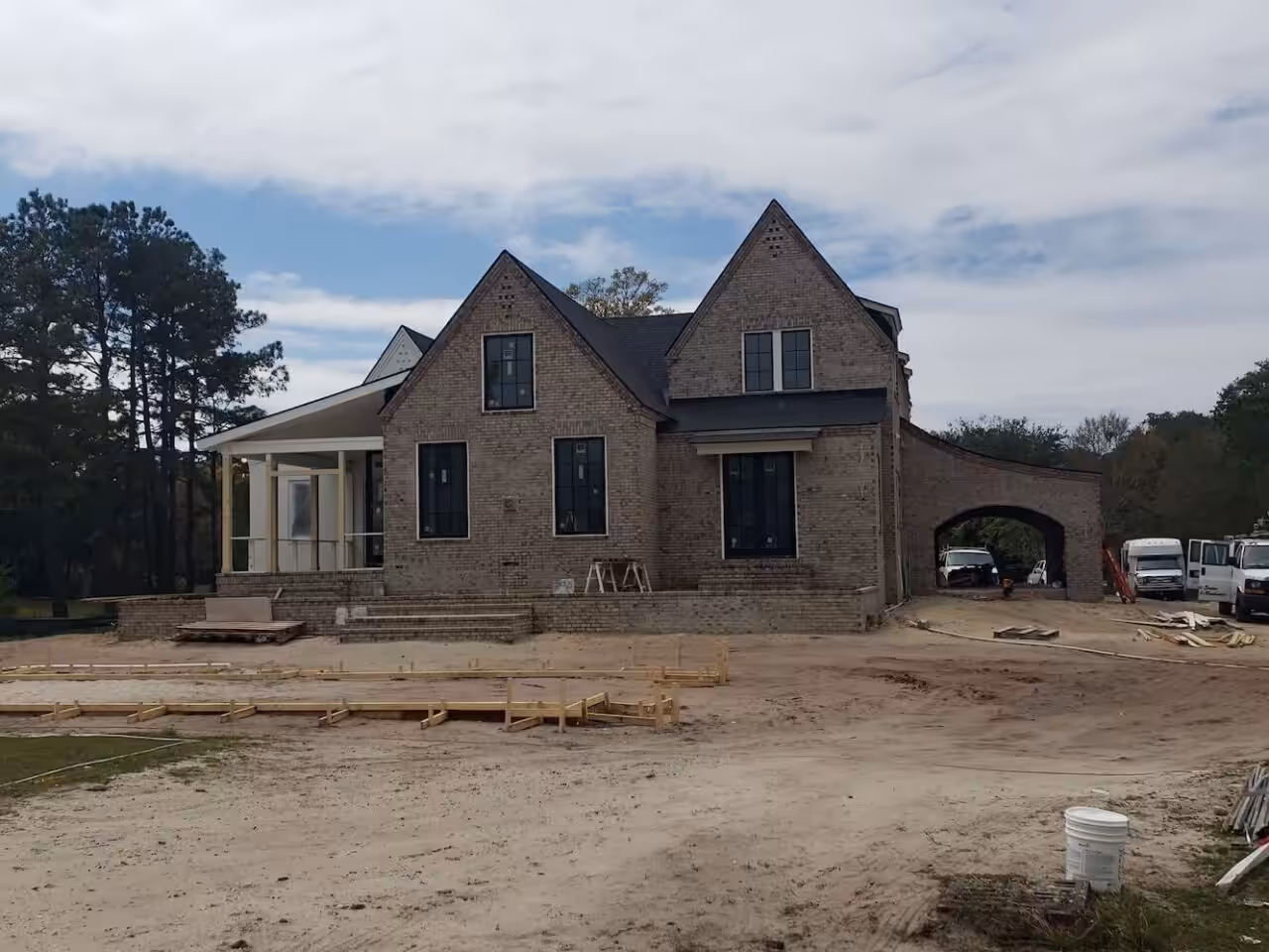 New farmhouse in Mount Pleasant with unpainted masonry walls and a dirt yard during construction